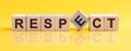 Respect word is made of wooden building blocks lying on the yellow table, concept Royalty Free Stock Photo