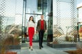 Respectable businessman and fashionable asian business woman walking near office