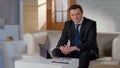 Respectable businessman sitting on couch in modern office, successful career