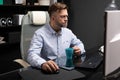 Business man with glasses working in office at computer table and drinking coffee from bright Cup Royalty Free Stock Photo