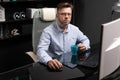 Business man with glasses working in office at computer table and drinking coffee from bright Cup Royalty Free Stock Photo