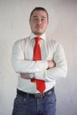 A respectable man in a business style in a white shirt with a red tie and large hands on a white background.