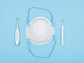 Respirator, electronic and mercury thermometer on a blue background