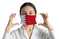 Respirator with flag of Bahrain Doctor puts on medical face mask isolated on white background