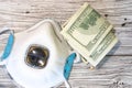 Respiratory breath protection mask with dollar banknotes top view. Flat lay concept about money, drugs and healthcare