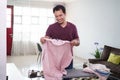 responsible husband busy with house work, irones his shirt in morning