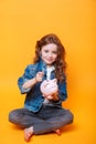 Responsible girl putting money into piggy bank for future saving Royalty Free Stock Photo