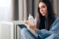 Mother Holding Milk Bottle Keeping a Baby Food Journal