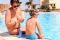 Responsible mother applying sunscreen on her son