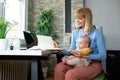 Responsible mother working at the office and holding her baby