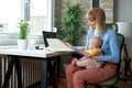 Responsible mother working at the office and holding her baby