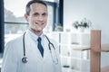 Responsible pleasant medic standing and smiling. Royalty Free Stock Photo