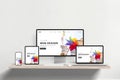 Responsive web design studio page displayed across laptop, phone, tablet, and computer on office desk