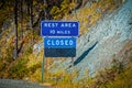 Rest Area sign with Closed posted below it on side of USA road by a steep incline in Autumn Royalty Free Stock Photo