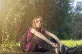 Rest while hiking. young caucasian woman hiker sitting in forest relaxing during hike. woman with backpack