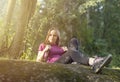 Rest while hiking. young caucasian woman hiker sitting in forest relaxing during hike. woman with backpack