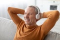 Calm mature man having rest at home listening to music Royalty Free Stock Photo