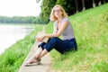 Rest relax and hobby. Summer vacation. Girl sit on green grass near river and read book. Girl relaxing at riverside