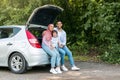 Rest and relax at road. Happy young arab male and female in hijab with small son sitting in car trunk Royalty Free Stock Photo