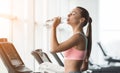 Rest after running. Woman drinking water, exercising on treadmill Royalty Free Stock Photo
