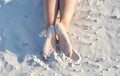 Rest on the seaside, laying in the sun on the beach concept. A close up of woman`s legs with feet soles covered with sand at sea Royalty Free Stock Photo