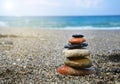 Rest in summer concept. Stones piled on the beach against the sea, copy space, sunlight