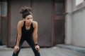 Rest during workout outdoor. African american girl with fitness tracker relaxation from jogging