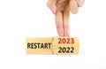 2023 restart new year symbol. Businessman turns a wooden cube and changes words Restart 2022 to Restart 2023. Beautiful white