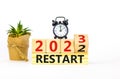 2023 restart new year symbol. Turned wooden cube and changes words Restart 2022 to Restart 2023. Black alarm clock. Beautiful