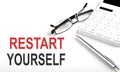 RESTART YOURSELF Concept. Calculator,pen and glasses on the white background