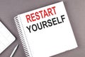 RESTART YOURSELF text on notebook with calculator and pen,business concept