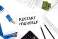 RESTART YOURSELF Words on the card with keyboard and office tools