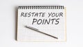 RESTATE YOUR POINTS text on the notepad with pen Royalty Free Stock Photo