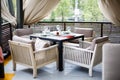 A restaurant with beautifully furnished interiors, comfortable armchairs and served tables on a spacious outdoor terrace