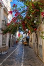 Restaurant and bougainvillea flower in narrow street in Tavira, Portugal