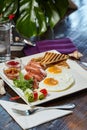 Restaurant breakfast composition image. On a wooden table with a green leaf background