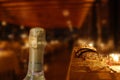 Restaurant by candlelight with champagne bottle in foreground Royalty Free Stock Photo