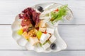 Restaurant cheese plate - various types of cheeses with grapes and black olive on white plate. Top view