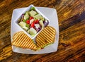 Gourmet grilled cheese, turkey, avocado, sun dried tomato sandwich with bowl of salad.