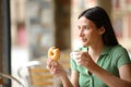 Restaurant customer at breakfast eating doughnut and drinking Royalty Free Stock Photo