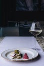Restaurant delicacy dish on a purple tablecloth with glass of white wine. Royalty Free Stock Photo