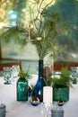 Restaurant design.A table covered with a white tablecloth, a classic serving. Bottles of blue and green glass. Paws ate.