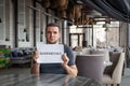 Restaurant director is holding white sheet of paper with word Quarantined