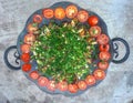 Restaurant dish on concrete background. Azerbaijani saj, mushrooms, vegetables and greens, and tomatoes laid out in a circle Royalty Free Stock Photo