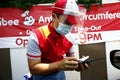 Restaurant employee with PPE serve a customer at the drive thru facility of a fast food restaurant