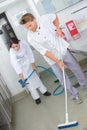 Restaurant employees cleaning kitchen floor