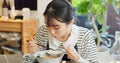 Restaurant, food and Japanese woman with noodles for eating meal, lunch and dinner in cafe. Ramen, cafeteria supper and Royalty Free Stock Photo