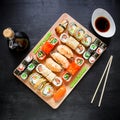 Restaurant food. Sushi rolls, soy sauce and traditional chopsticks on a black background. Top view. Flat lay. Royalty Free Stock Photo