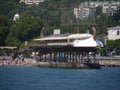 A restaurant in the form of a sailing boat at the pier near the beach with a lot of holidaymakers. Yalta Crimea