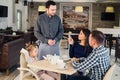 Restaurant and holiday concept - waiter giving menu to happy family at cafe